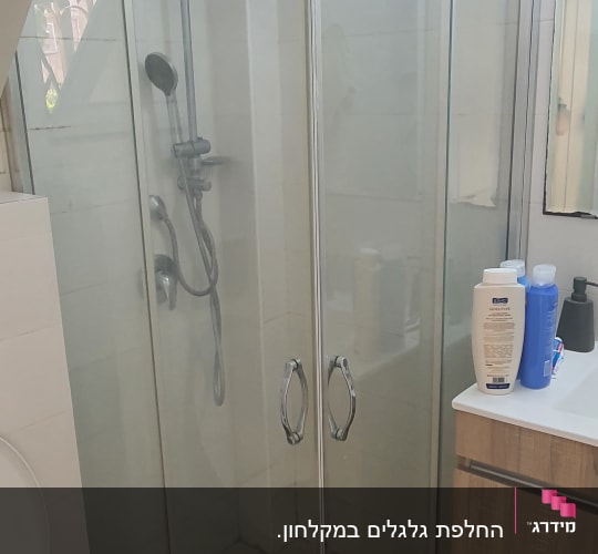 מקלחון זכוכית עם דלתות שקופות וידיות מתכת